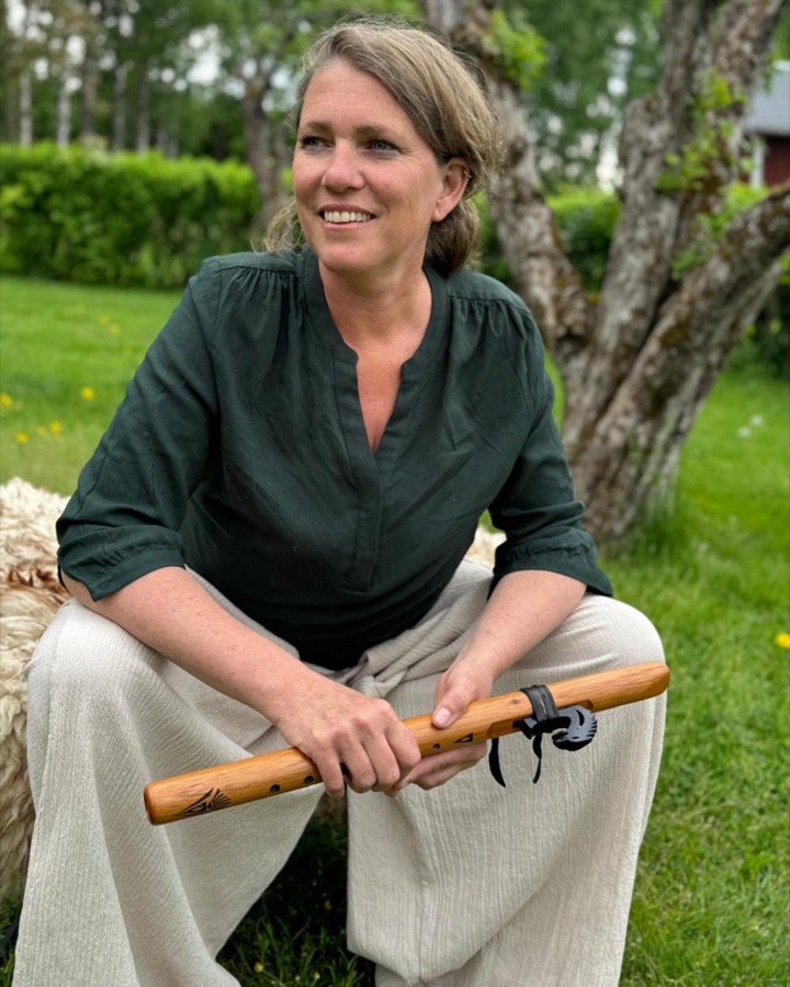Anne-Marie van Tilburg in de tuin, met een fluit in haar handen