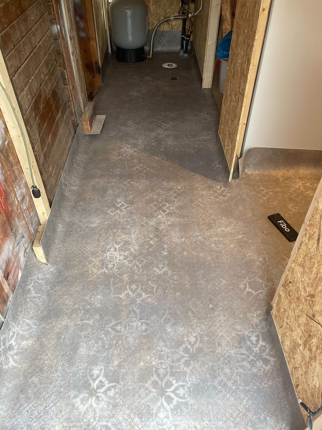 De nieuwe vloer in de gang van het huis, met de wanden nog in ruwe plaat