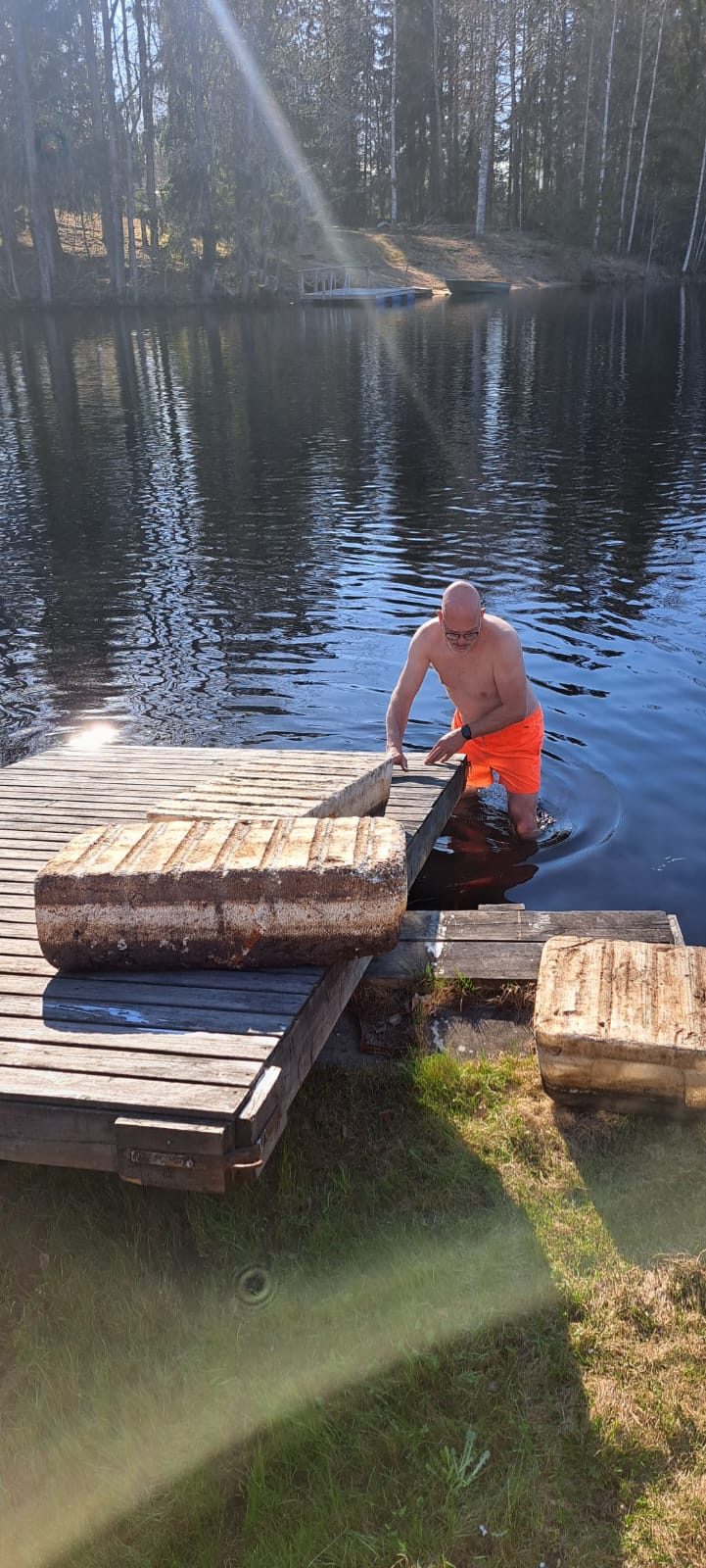 Iemand daalt via de badtrap van de steiger het koude water in