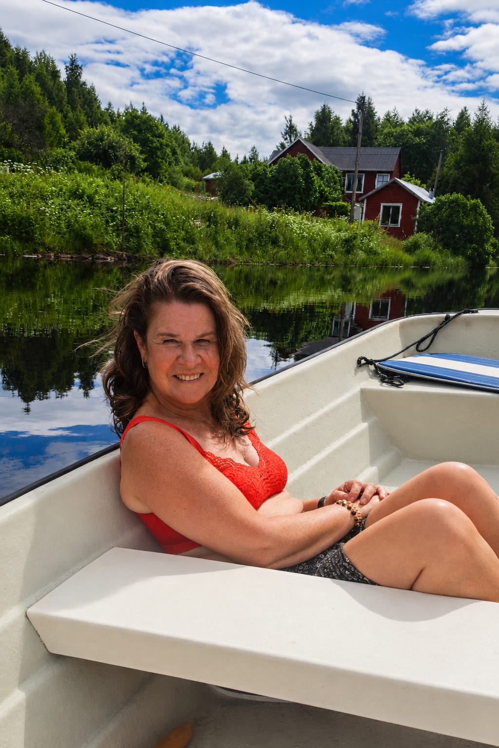 Marion in de boot op het meer bij Ockelbo, met het rode huis aan de overkant