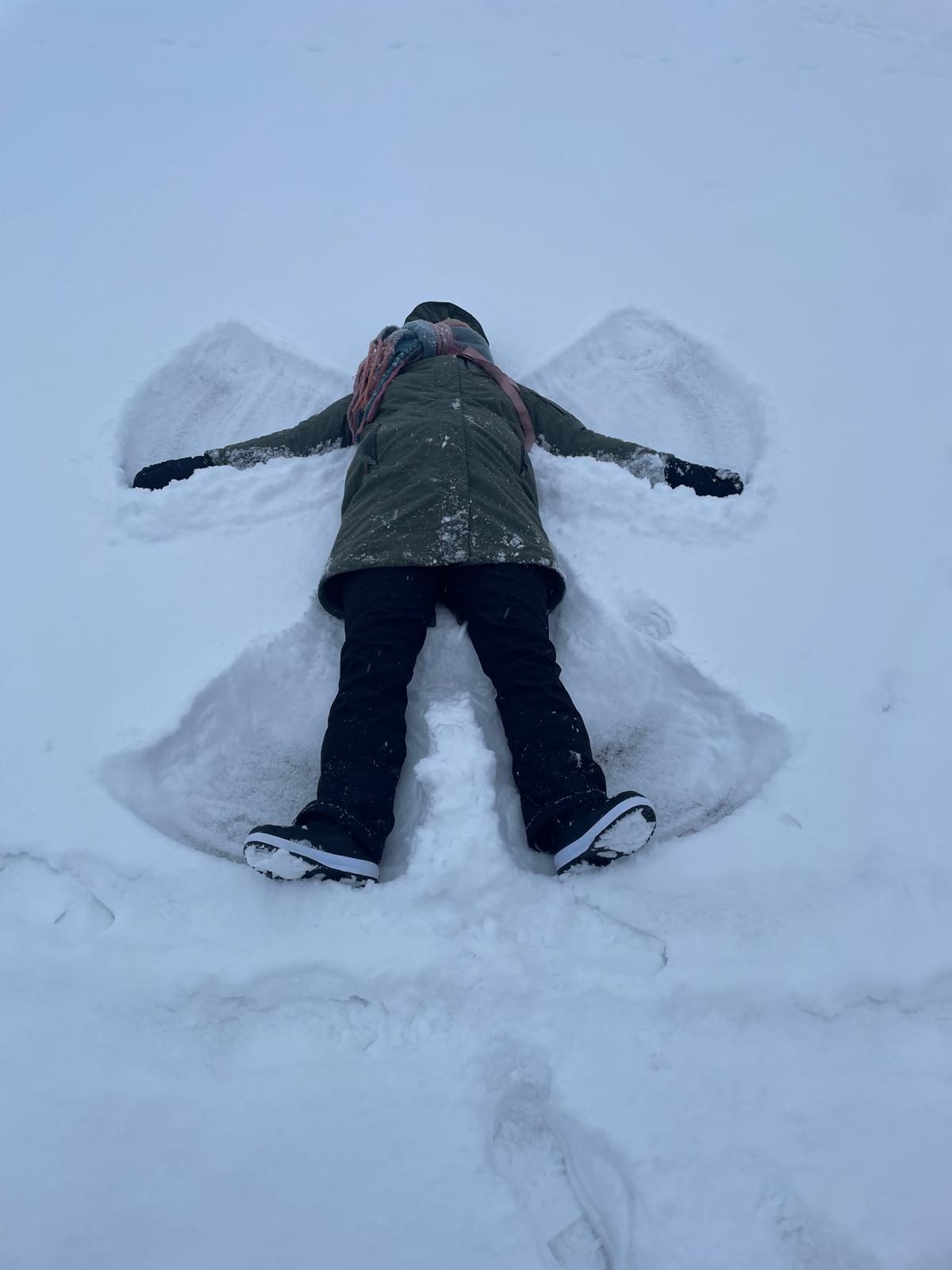 Een sneeuwengel in het verse pak sneeuw bij het huis
